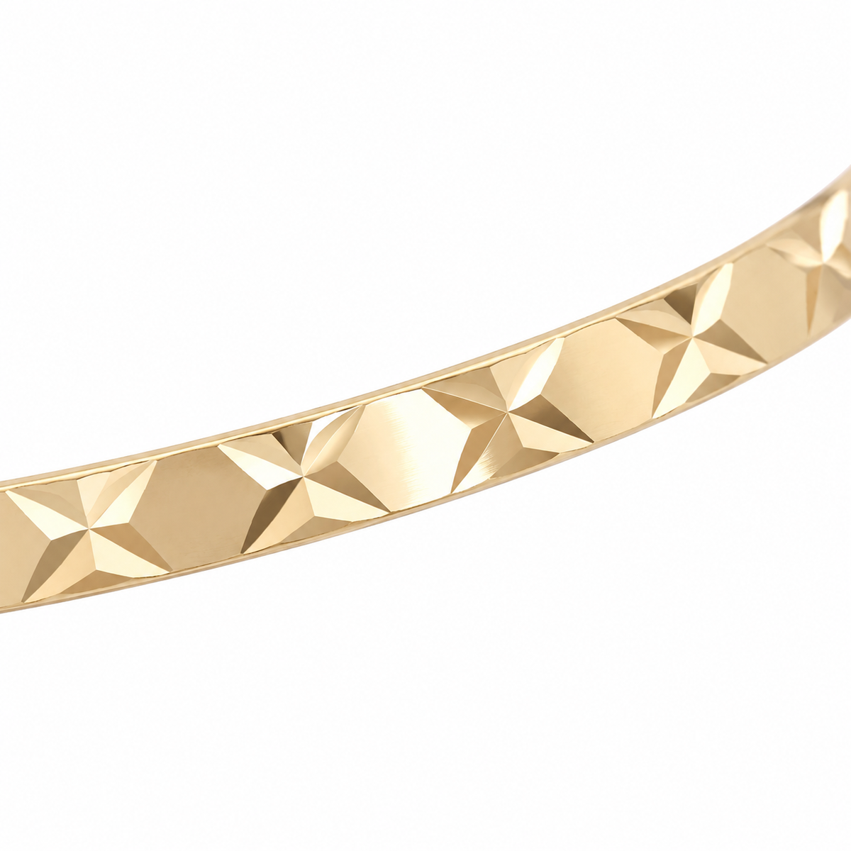 Close detail of the diamond cut pattern on a 9ct gold bangle