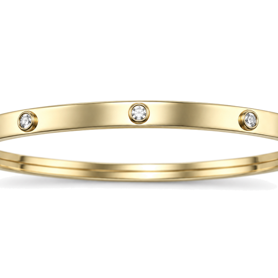 Close detail of the rubbed over cubic zirconia settings on a 9ct gold children's bangle