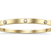 Close detail of the rubbed over cubic zirconia settings on a 9ct gold children's bangle