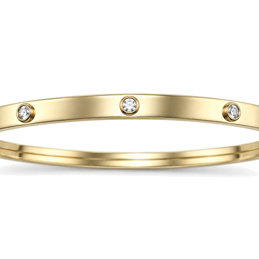 Close detail of the rubbed over cubic zirconia settings on a 9ct gold children's bangle