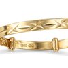 Close detail of the diamond cut star pattern and the 375 hallmark on a 9ct gold children's bangle