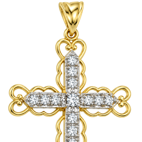 Close detail of the scrolled filigree arms and the set cubic zirconia on a 9ct gold cross pendant